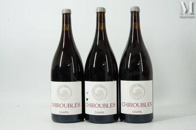 trois bouteilles de vin rouge sont alignées sur une surface blanche