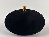 a close up of a black purse on a white surface