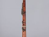 a close up of a clarinet on a clear surface with a gray background