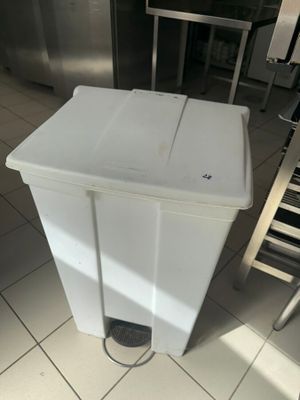 a white trash can sitting on the floor in the kitchen