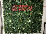 a green wall with a sign on it that says so simple so happy