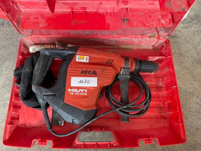 a red tool box with a drill and a cord in it