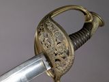 an antique sword with gold decoration on the blade of it