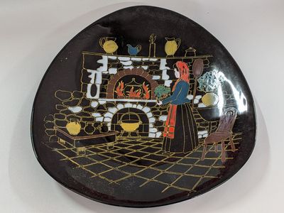 a black plate with a picture of a woman and a fireplace