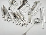 a lot of silverware on a table with spoons and knives