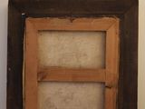an old picture frame sitting on top of a floor next to a wall