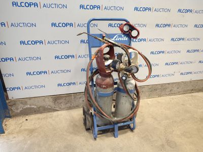 un chariot bleu sur lequel se trouvent un bidon d'essence et un tuyau