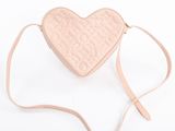 a pink heart shaped purse with a strap on a white background