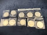 six different types of gold coins in plastic bags on a black surface