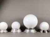trois boules de verre blanches posées les unes à côté des autres sur une table