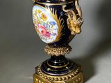 a vase with a dragon on it sitting on a stand