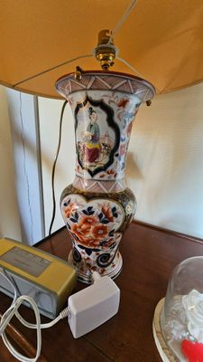 une lampe posée sur une table à côté d'un téléphone
