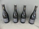 four bottles of wine are lined up on a table