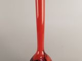 un vase rouge posé sur une table