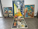 de nombreux tableaux posés par terre dans une pièce