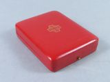 a small red box with a gold cross on it