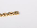 an image of a gold bracelet on a white surface