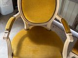 une vieille chaise avec un dossier et des accoudoirs tapissés de jaune