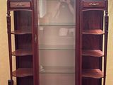 a display cabinet with a glass door in the corner