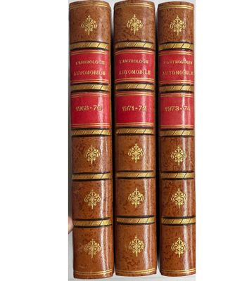 trois vieux livres posés l'un sur l'autre sur une surface blanche