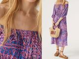 a woman wearing a purple dress and a straw bag