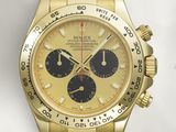 an image of a gold and black watch on a white surface