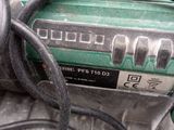 a close up of a green and black corded drill