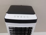 an air conditioner sitting on top of a white table next to a wall