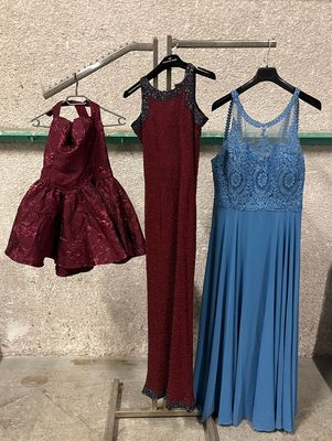 three dresses hanging on a clothes rack in a room