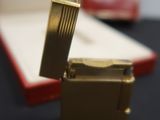 a gold lighter sitting in a red box on a table