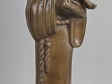 a bronze statue of a person holding a bird on a stick