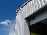 une porte jaune devant un immeuble, avec un ciel bleu en arrière-plan