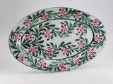 an oval platter decorated with flowers and leaves on a white background