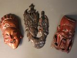 three wooden masks on the wall of a room