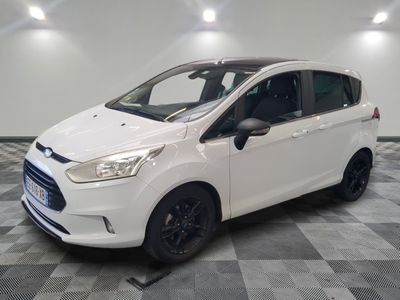 a white ford b - max parked on a checkered floor