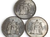 three silver coins with the image of a man and a woman on them