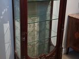 a display case with a glass door in the corner of a room