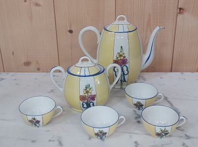 quatre tasses et une théière posées sur une table