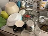 a sink with a lot of dirty dishes and cups on it
