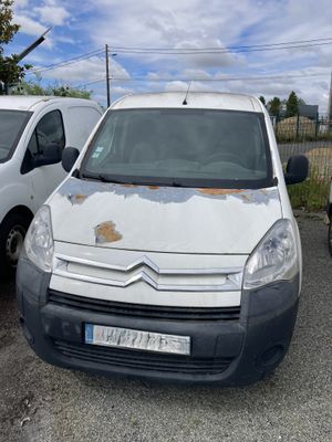 une camionnette blanche garée dans un parking avec d'autres voitures