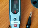 un petit appareil électronique posé sur une table en bois, à côté d'un stylo