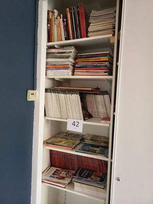 une bibliothèque remplie de livres, dans un coin de la pièce