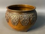 a gold bowl with a design on it on a white surface