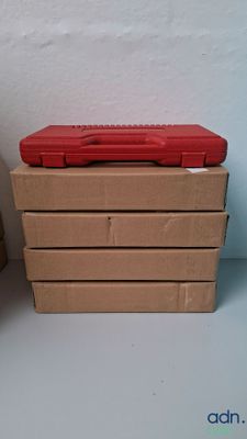 a red toolbox sitting on top of a stack of brown boxes