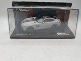 a white toy car in a clear box on a table