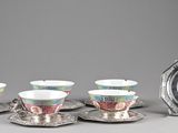 cinq tasses et soucoupes posées sur un plateau en argent