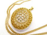 collier plaqué or composé d'une chaîne et d'un pendentif orné d'un motif floral