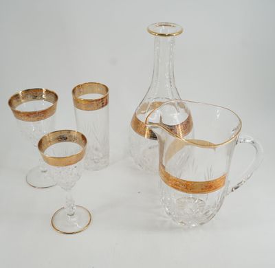 trois verres et une carafe posés sur une surface blanche
