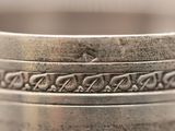 a close up of a silver ring with a design on it