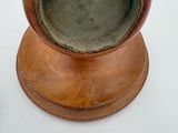 a brown vase sitting on top of a wooden stand